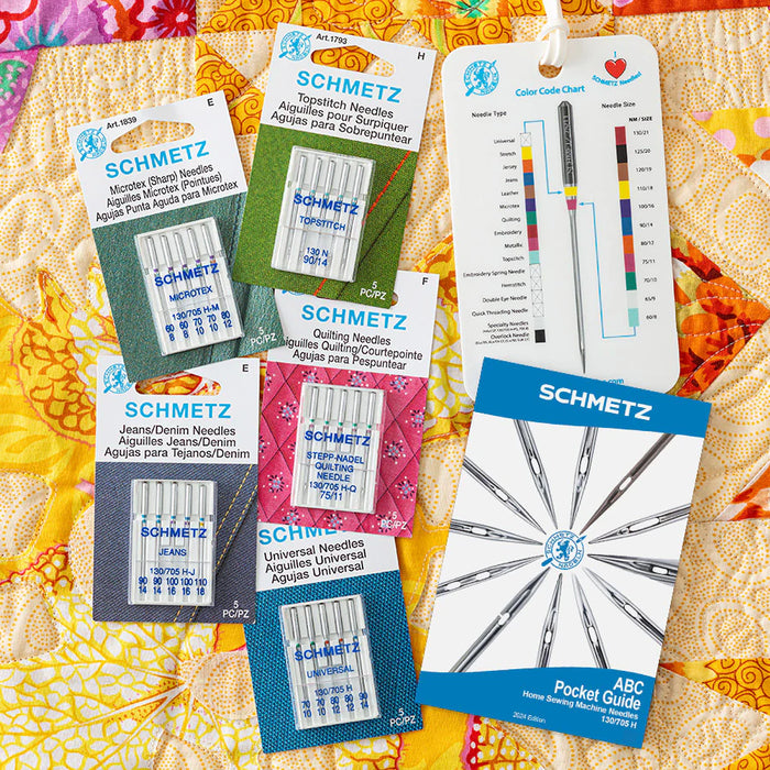 Collection of Schmetz needle piecing & quilting bundle and a color chart on a quilt background