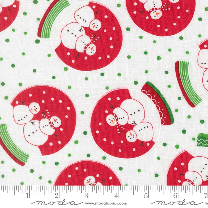 Snow Time Winter White Snowglobe fabric shown beside a ruler to display the print scale and repeat width