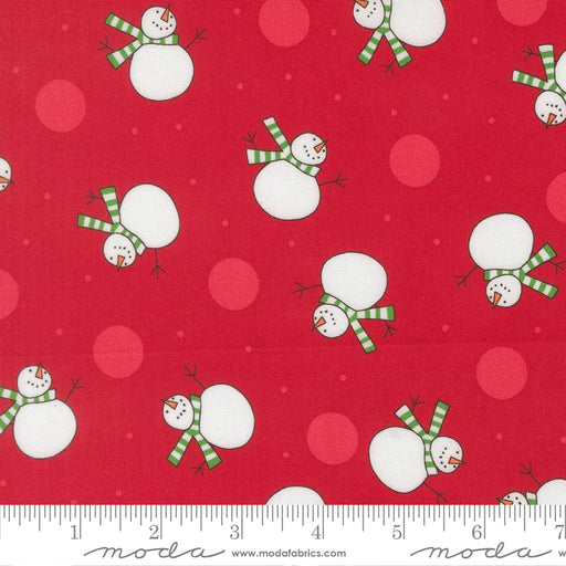 Snow Time Poinsettia Red Snowman fabric shown beside a ruler to display the print scale and repeat width