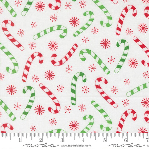 Snow Time Winter White Candy Cane fabric shown beside a ruler to display the print scale and repeat width