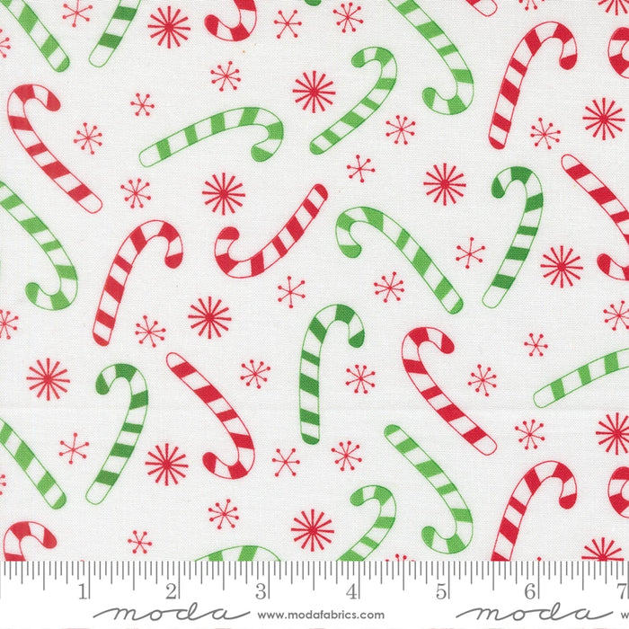 Snow Time Winter White Candy Cane fabric shown beside a ruler to display the print scale and repeat width