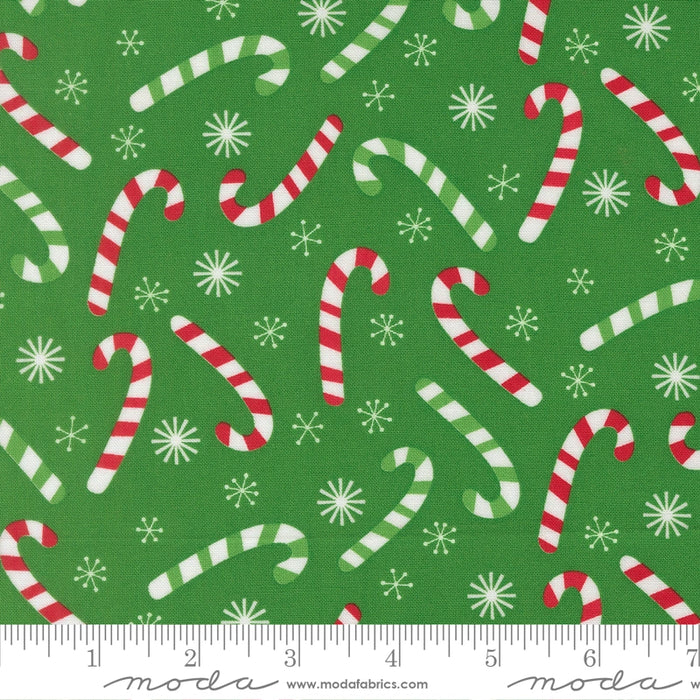Snow Time Evergreen Candy Cane fabric shown beside a ruler to display the print scale and repeat width