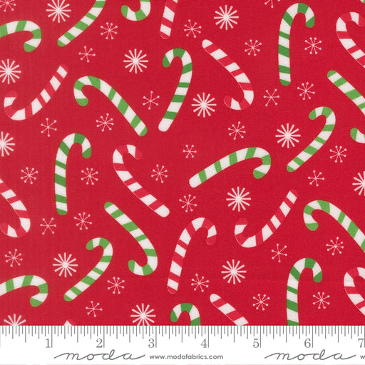 Snow Time Poinsettia Red Candy Cane fabric shown beside a ruler to display the print scale and repeat width