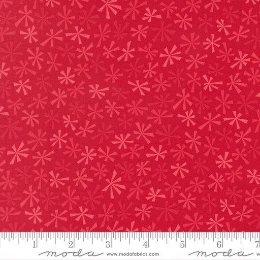 Snow Time Poinsettia Red Tinsel fabric shown beside a ruler to display the print scale and repeat width