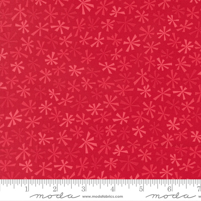 Snow Time Poinsettia Red Tinsel fabric shown beside a ruler to display the print scale and repeat width