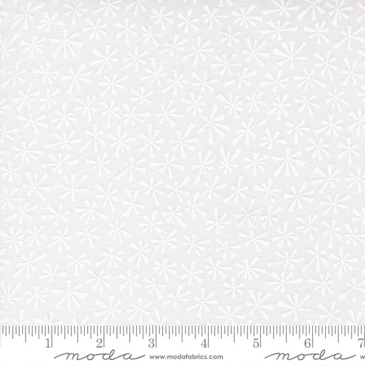 Snow Time Winter White on White Tinsel fabric shown beside a ruler to display the print scale and repeat width