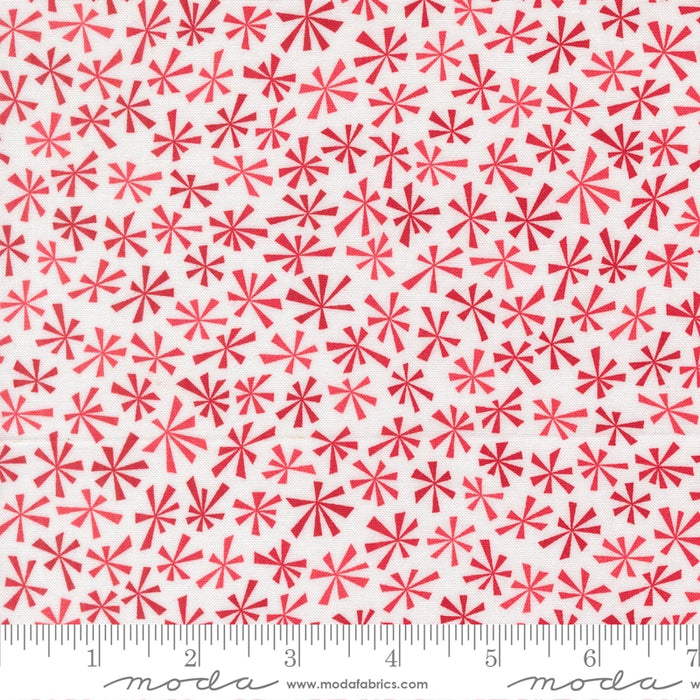 Snow Time Winter White and Red Tinsel fabric shown beside a ruler to display the print scale and repeat width