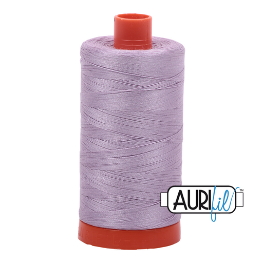 A spool of Aurifil 50wt lilac thread with a red cap.