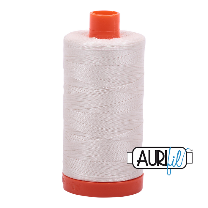 A spool of Aurifil thread Muslin colored #2311 on a orange spool and cap on a white background