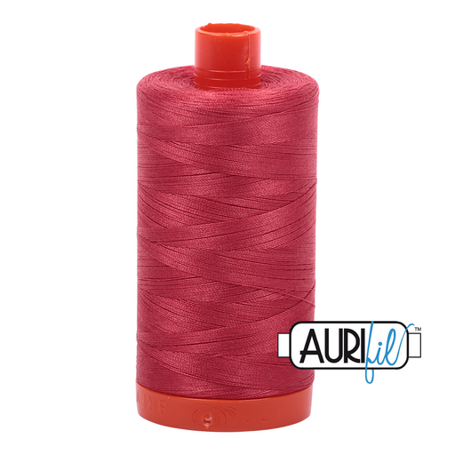 A spool of Aurifil 50wt red peony cotton thread.