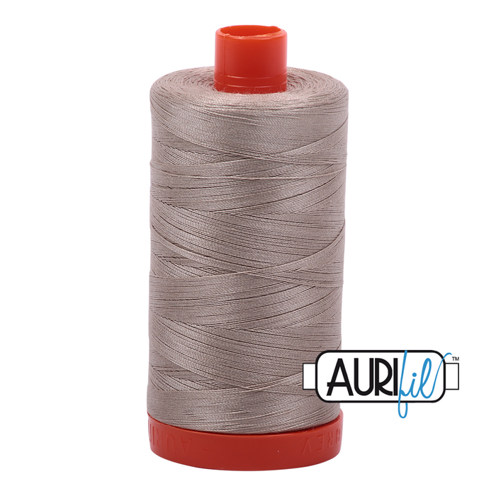 A spool of Aurifil 50wt rope beige cotton thread.