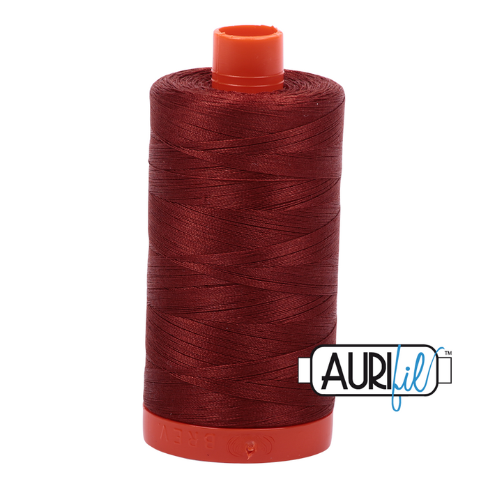 A spool of Aurifil 50wt rust-colored thread #2355 with orange cap.