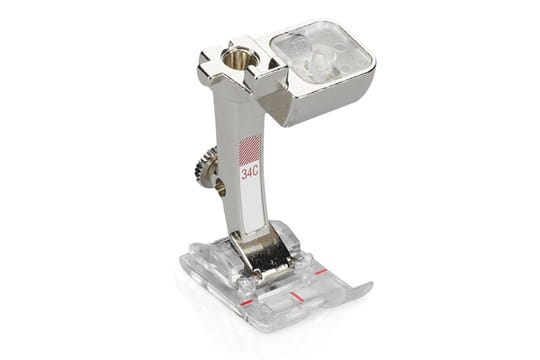 Bernina #34C Reverse Pattern Presser Foot with a clear sole, metal body, and red markings.