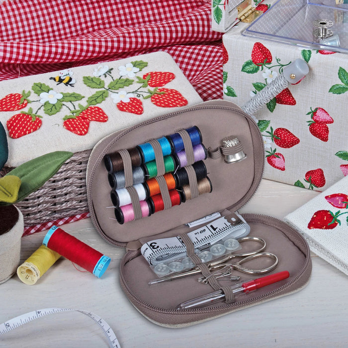 Sewing kit with thread and scissors on a fabric background