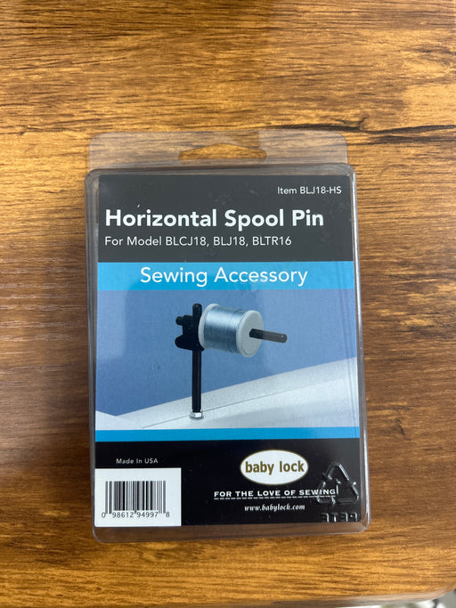Packaging of a horizontal spool pin for sewing accessories on a wooden surface