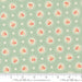 Fabric pattern with floral and polka dot design on a light green background, featuring Moda label.