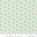 Fabric with small floral pattern on a light blue background, featuring Moda label.
