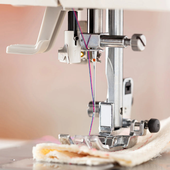 Close-up of a sewing machine needle and thread on a blurred background