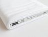 Tilda Solid White fabric roll with a label on a white background